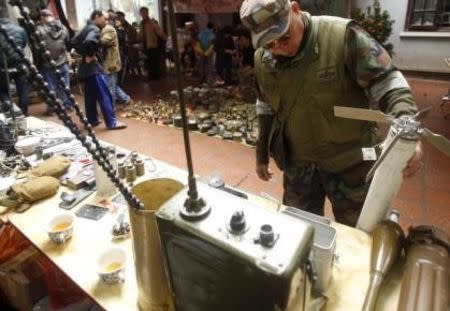 Vietnamese veteran Vu Van Bao, wearing the uniform of the U.S. Army's Alpha team, looks at a missile from a helicopter of the U.S. military which was used during the Vietnam War, at an old items market in Hanoi March 14, 2015. REUTERS/Kham