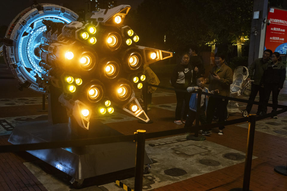 Visitors stand near a depiction of a space craft at an exhibition about "The Three-Body Problem" in Chengdu, Sichuan province on Friday, Oct. 20, 2023. The series that began with "The Three-Body Problem," written by former engineer Liu Cixin, helped Chinese science fiction break through internationally, winning awards and making it onto the reading lists of the likes of former U.S. President Barack Obama and Mark Zuckerberg. (AP Photo/Ng Han Guan)