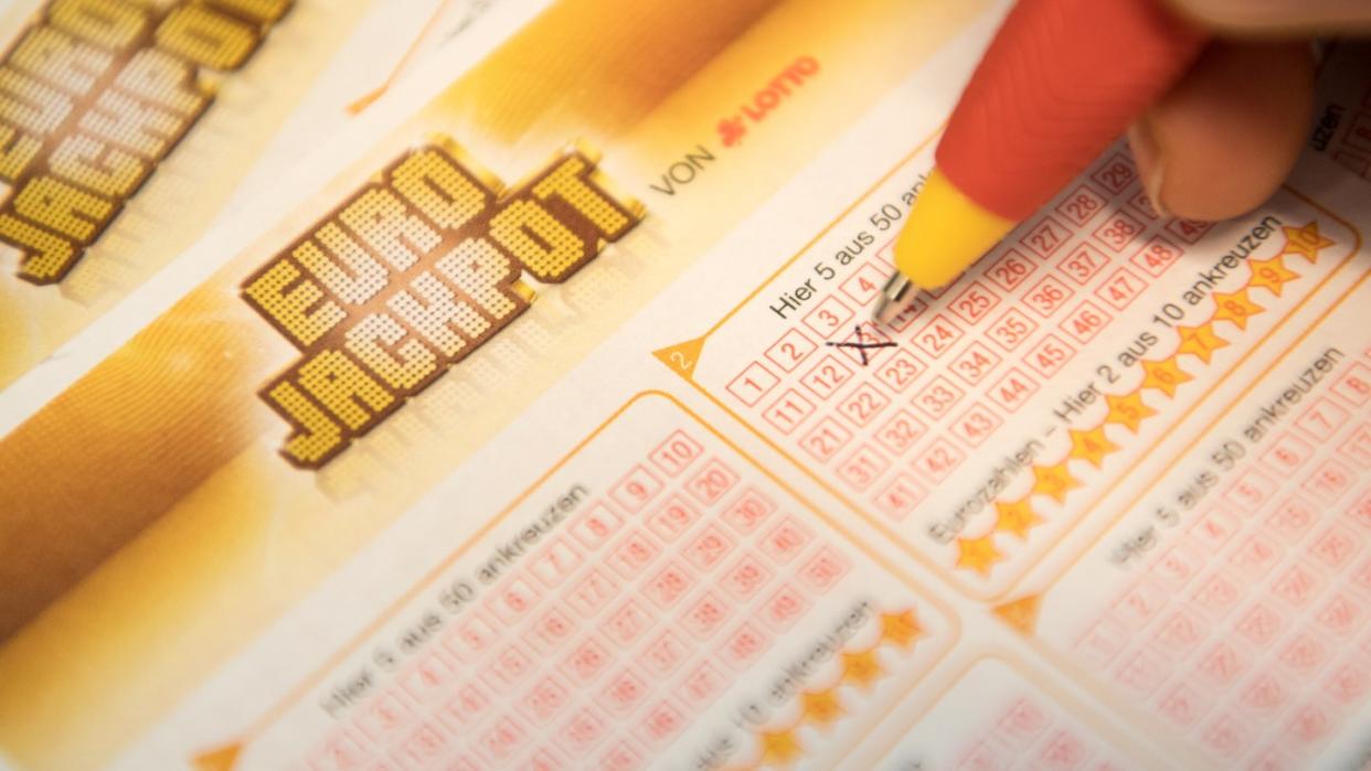 Eine Kundin füllt einen Eurojackpot-Lotterie-Schein aus. Foto: Fabian Sommer/Archiv