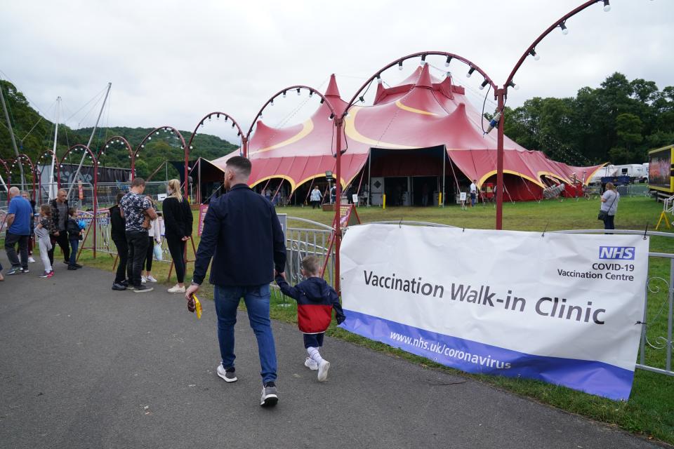 People walk past signs for the pop-up Covid-19 vaccination clinic by Circus Extreme in Halifax (Owen Humphreys/PA) (PA Wire)