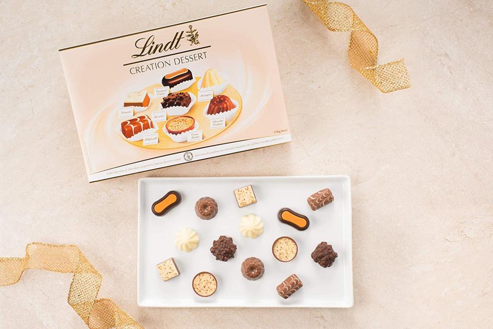 Box of Lindt Creation Dessert Gift Box with chocolates displayed on a white tray.