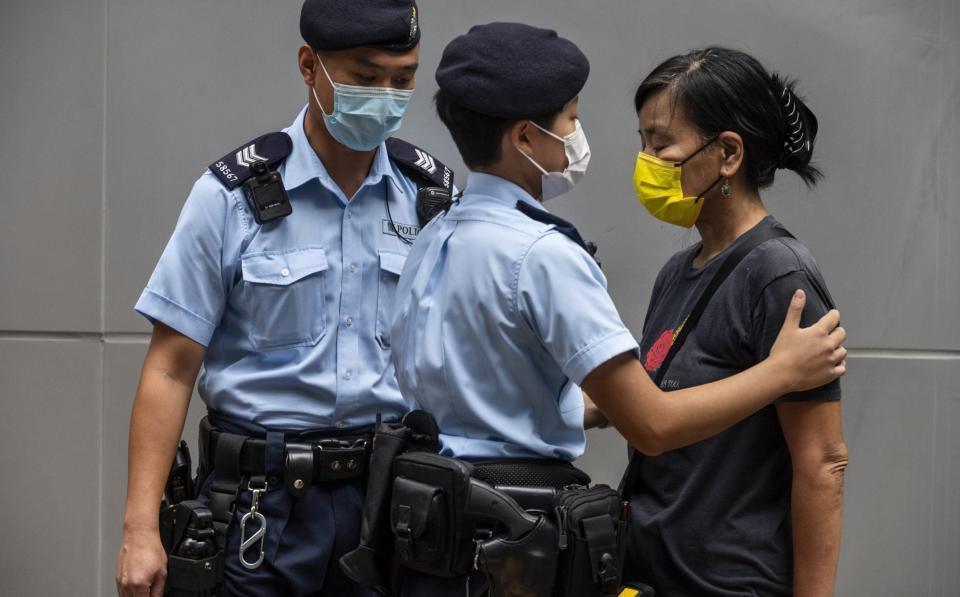 An activist is stopped and searched by police officers during a pro-democracy protest on July 1, 2021 - Anadolu Agency 