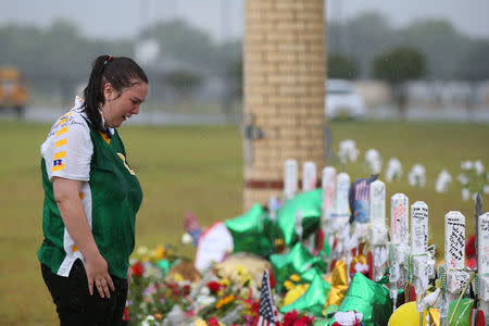 Santa Fe High School student Sierra Dean mourns the death of her friends killed in a recent shooting at a makeshift memorial left in their memory at Santa Fe High School in Santa Fe, Texas, U.S., May 23, 2018. REUTERS/Loren Elliott
