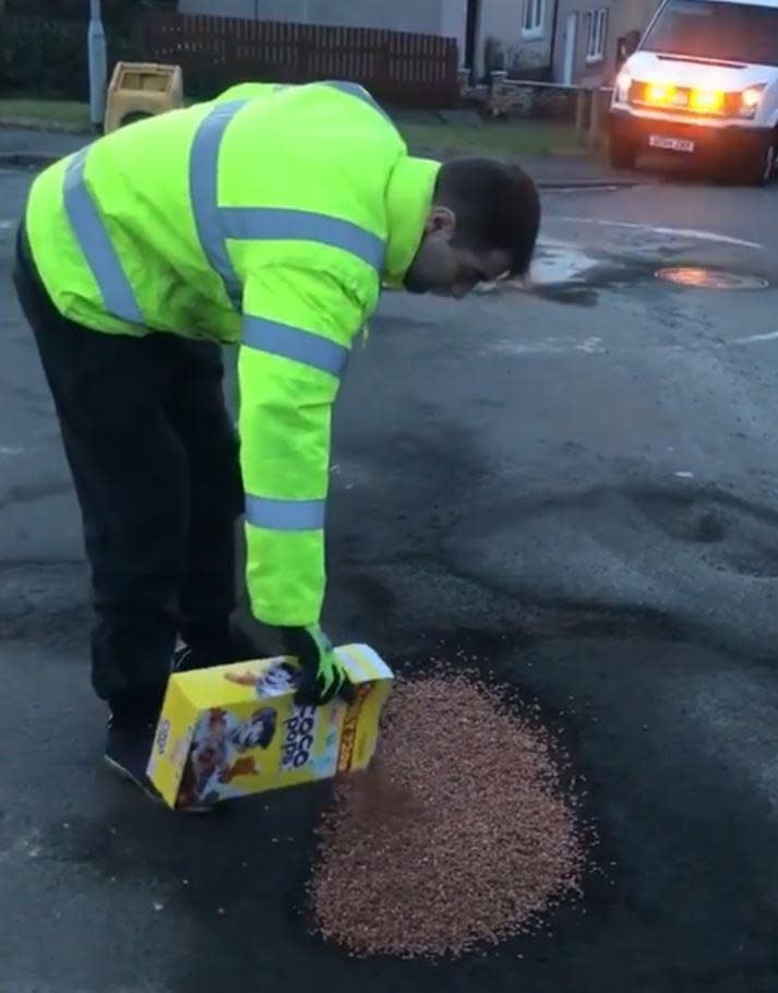 A man pours cocopops into a pothole