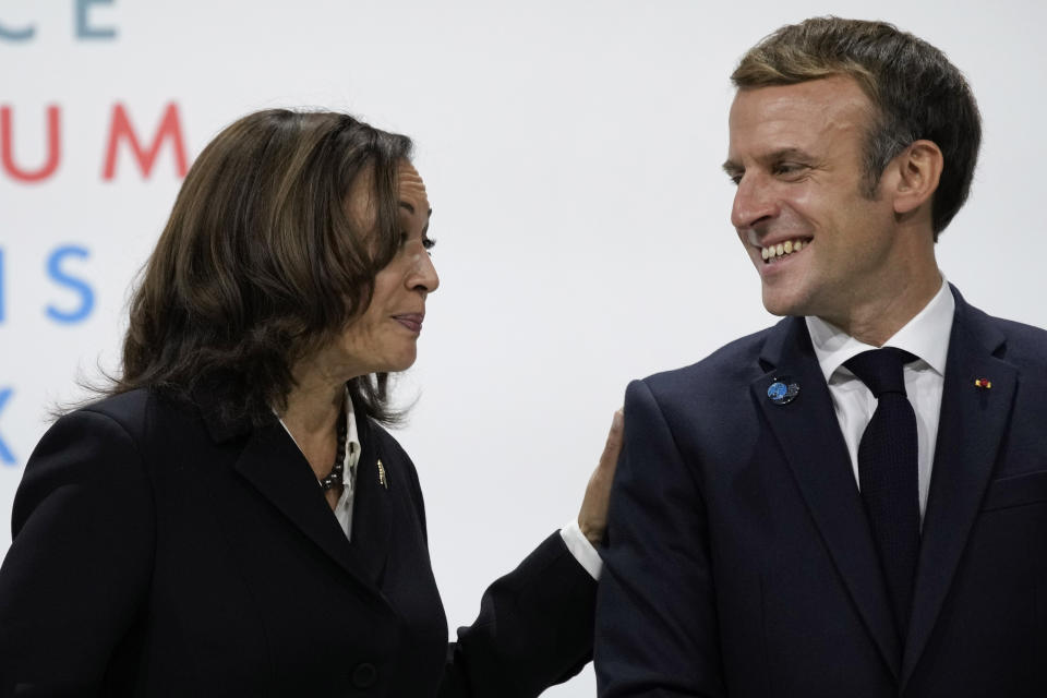 France's President Emmanuel Macron, right, laughs with U.S Vice President Kamala Harris, during the Paris Peace Forum, in Paris, Thursday, Nov. 11, 2021. Some world leaders and internet giants are expected to issue a global call to better protect children online during a Paris summit of about 30 heads of state and government, including U.S. Vice-President Kamala Harris. (AP Photo/Christophe Ena)