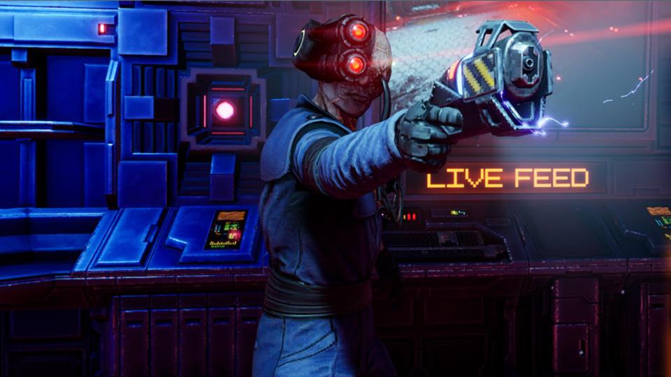 Cyborg man holding a laser pistol in front of  monitor that says 