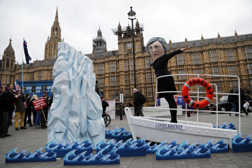 An activist from Avaaz wears a mask of Britain's Prime Minister Theresa May as Pro-European demonstrators protest opposite the Houses of Parliament in London, Tuesday, Jan. 15, 2019. Britain's Prime Minister Theresa May is struggling to win support for her Brexit deal in Parliament. Lawmakers are due to vote on the agreement Tuesday, and all signs suggest they will reject it, adding uncertainty to Brexit less than three months before Britain is due to leave the EU on March 29. (AP Photo/Frank Augstein)