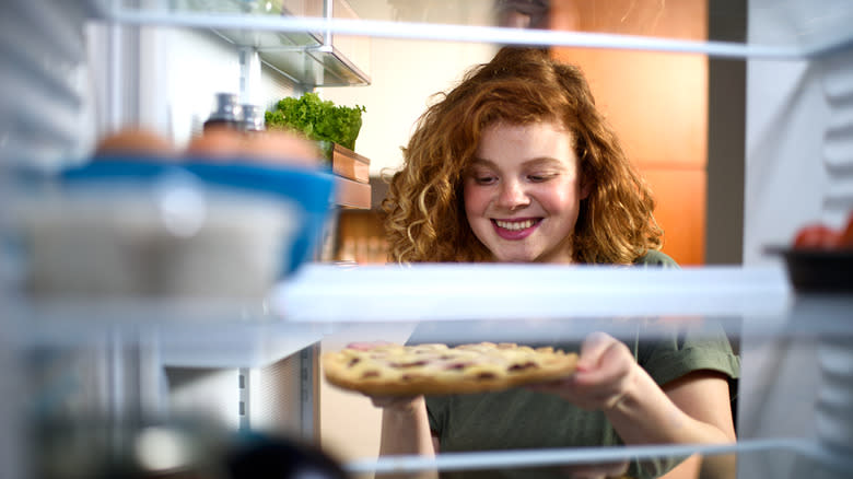 woman putting pie in the fridge