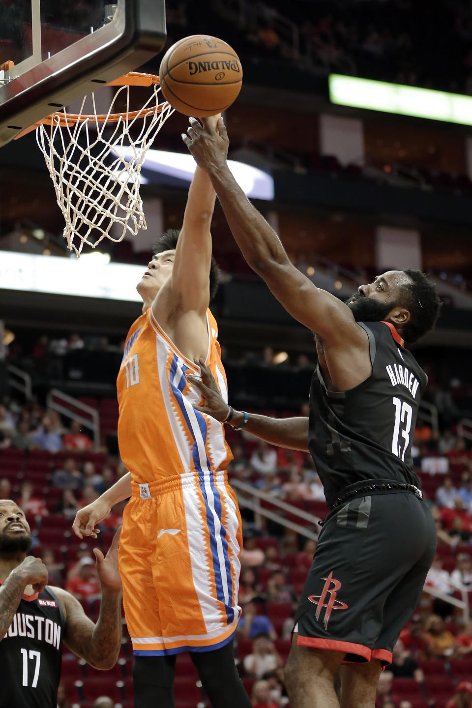 Shanghai Sharks center Dong Hanlin (10) is fouled on his layup by Houston Rockets guard James Harden (13) during the first half of an NBA basketball preseason game Monday, Sept. 30, 2019, in Houston. (AP Photo/Michael Wyke)