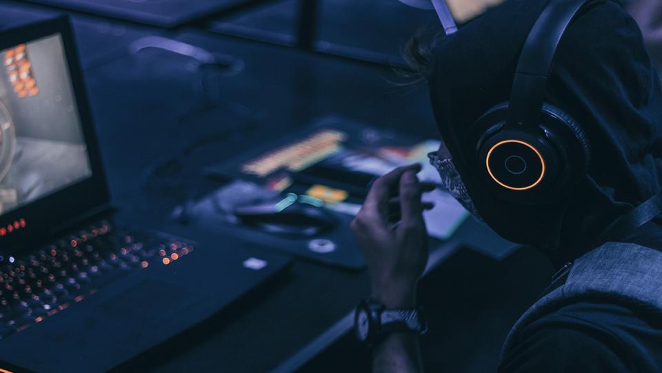 a dark room with a person listening to head phones while playing a video game