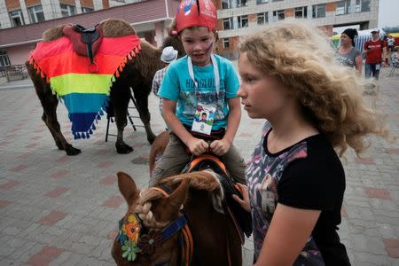 A young soccer fan rides a pony in Bor, Nizhny Novgorod, Russia July 1, 2018. REUTERS/Damir Sagolj