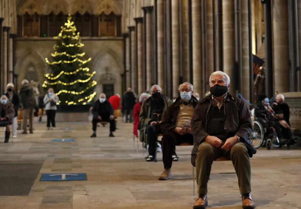 People sit and relax after receiving their Pfizer-BioNTech vaccination at Salisbury Cathedral in Salisbury, England, Wednesday, Jan. 20, 2021. Salisbury Cathedral opened its doors for the second time as a venue for the Sarum South Primary Care Network COVID-19 Local Vaccination Service. (AP Photo/Frank Augstein)