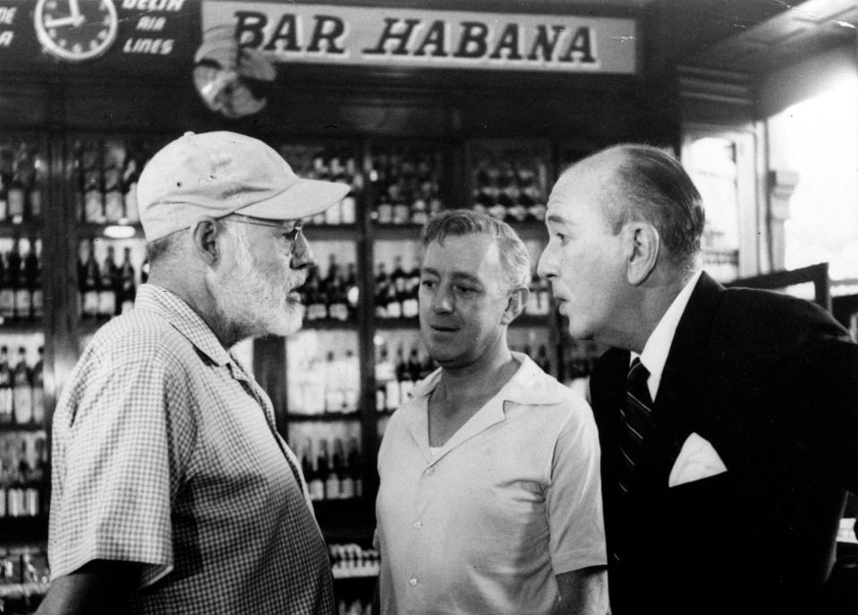 FILE - In this May 12, 1959, American novelist Ernest Hemingway, left, speaks with actors Alec Guinness, center, and Noel Coward in Sloppy Joe's Bar during the making of Sir Carol Reed's film version of "Our Man in Havana," based on Graham Greene's best seller, in Havana, Cuba. Sloppy Joe's will be reopened in February 2013 by the state-owned tourism company Habaguanex, part of an ambitious revitalization project by the Havana City Historian's Office, which since the 1990's has transformed block after block of crumbling ruins into rehabilitated buildings along vibrant cobblestone streets, giving residents and tourists from all over the chance to belly up to the same bar that served thirsty celebrities like Rock Hudson, Babe Ruth and Ernest Hemingway. (AP Photo, File)