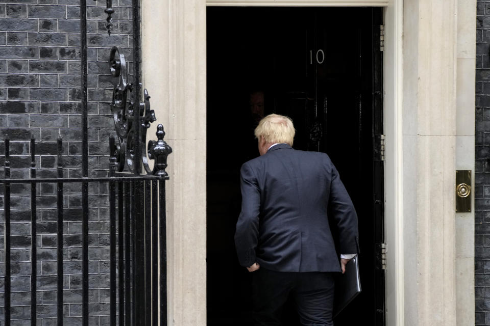 Prime Minister Boris Johnson walks back inside after reading a statement outside 10 Downing Street, London, formally resigning as Conservative Party leader, in London, Thursday, July 7, 2022. Johnson said Thursday he will remain as British prime minister while a leadership contest is held to choose his successor. (AP Photo/Frank Augstein)