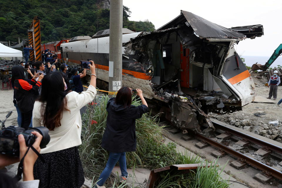 台灣日前發生致命的火車出軌事件，損壞車廂從隧道移出時，在場記者使用相機記錄畫面。圖片來源：Reuters。