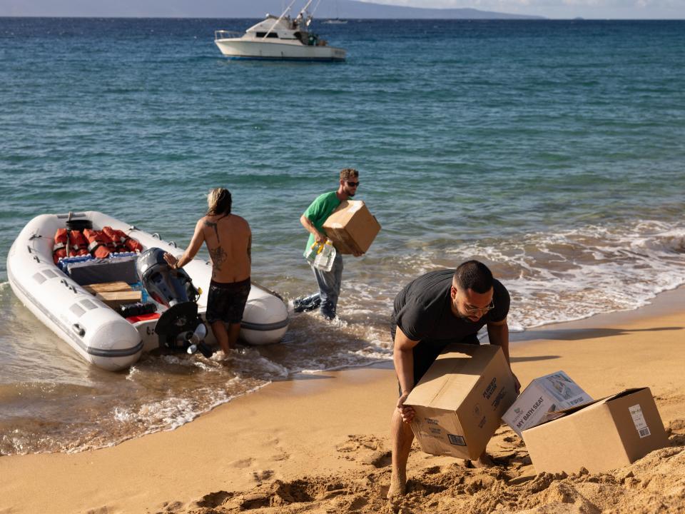 Volunteers sort out donations for those affected by a wildfire, at a parking lot in Lahaina, western Maui, Hawaii on August 12, 2023.