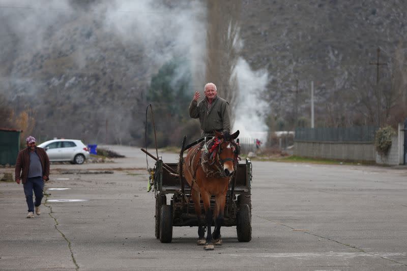 A local man riding a horse gestures on a former runaway of a military airport, in Gjader