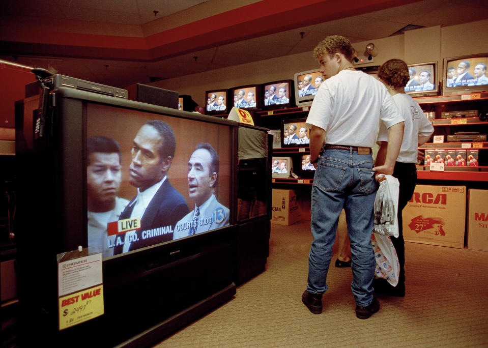 <p>The nation continued to be transfixed by the Simpson saga. Mall shoppers in Tampa, Fla.,watch banks of televisions in an electronics store, June 20, 1994, as O.J. Simpson was arraigned in Los Angeles, Calif., for the alleged murder of his ex-wife and her male friend. Simpson, standing with his attorney Robert Shapiro, right, pled innocent to murder charges. (Photo: Chris O’Meara/AP) </p>