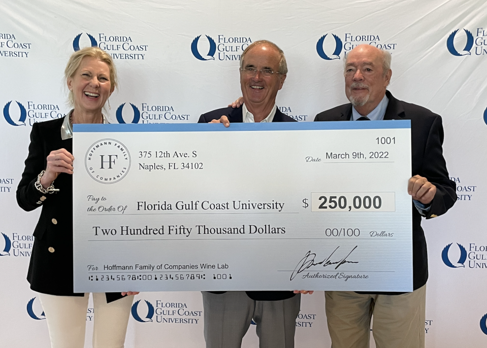 Photo of David Hoffmann (middle) holding a check of his donation to Florida Gulf Coast University.