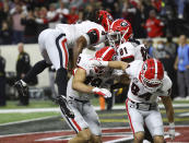 Georgia tight end Brock Bowers scores center celebrates with James Cook (from left) Marcus Rosemy-Jacksaint, and Ladd McConkey after scoring on a 15 yard pass to take a 26-18 lead over Alabama during the 4th quarter in the College Football Playoff Championship game on Monday, Jan. 10, 2022, in Indianapolis. (Curtis Compton/Atlanta Journal-Constitution via AP)