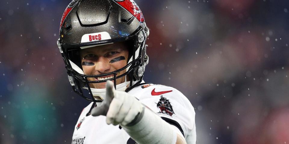 Tom Brady smiles and points during a game in 2022.