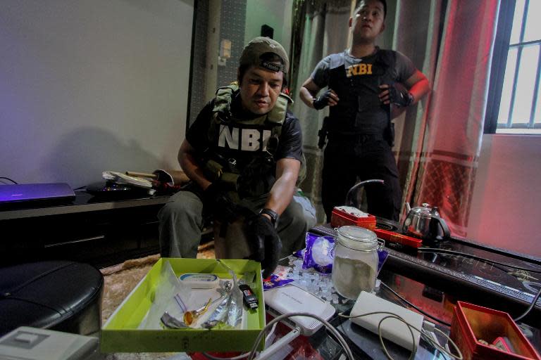 National Bureau of Investigation operatives confiscate prohibited items found inside the New Bilibid Prison in Muntinlupa, south of Manila on December 16, 2014