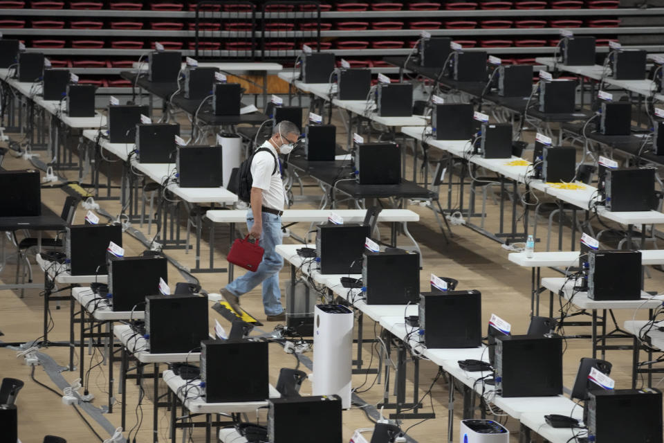 A worker walks past computers at the command center of the church-backed election watchdog Parish Pastoral Council for Responsible Voting, PPCRV, in Manila, Philippines on May 6, 2022. The winner of May 9, Monday's vote will inherit a sagging economy, poverty and deep divisions, as well as calls to prosecute outgoing leader Rodrigo Duterte for thousands of deaths as part of a crackdown on illegal drugs. (AP Photo/Aaron Favila)