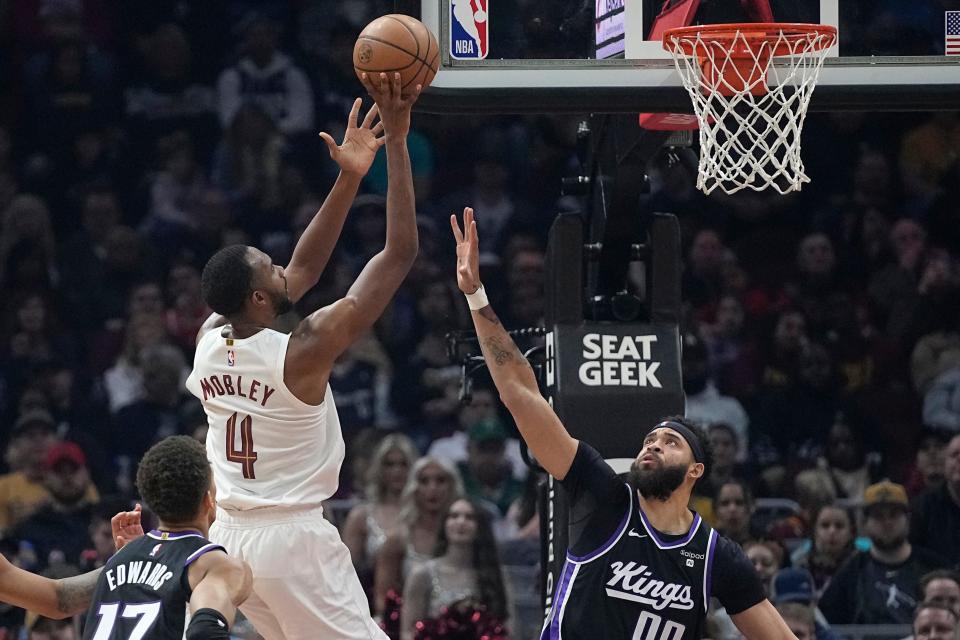 Cleveland Cavaliers forward Evan Mobley (4) shoots over Sacramento Kings center JaVale McGee, right, in the first half of an NBA basketball game, Monday, Feb. 5, 2024, in Cleveland. (AP Photo/Sue Ogrocki)