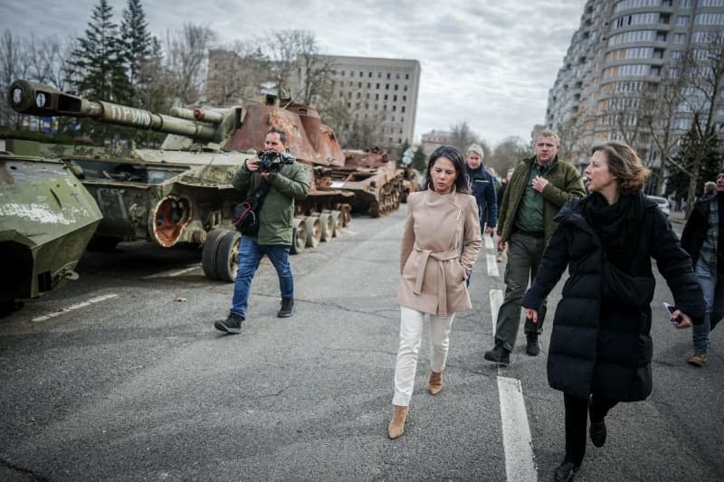 German Foreign Minister Annalena Baerbock, walks past destroyed Russian tanks during her visit to the former headquarters of the regional administration of Mykolaiv oblast. On March 29, 2022, the building was hit by Russian missiles and almost completely destroyed. Kay Nietfeld/dpa