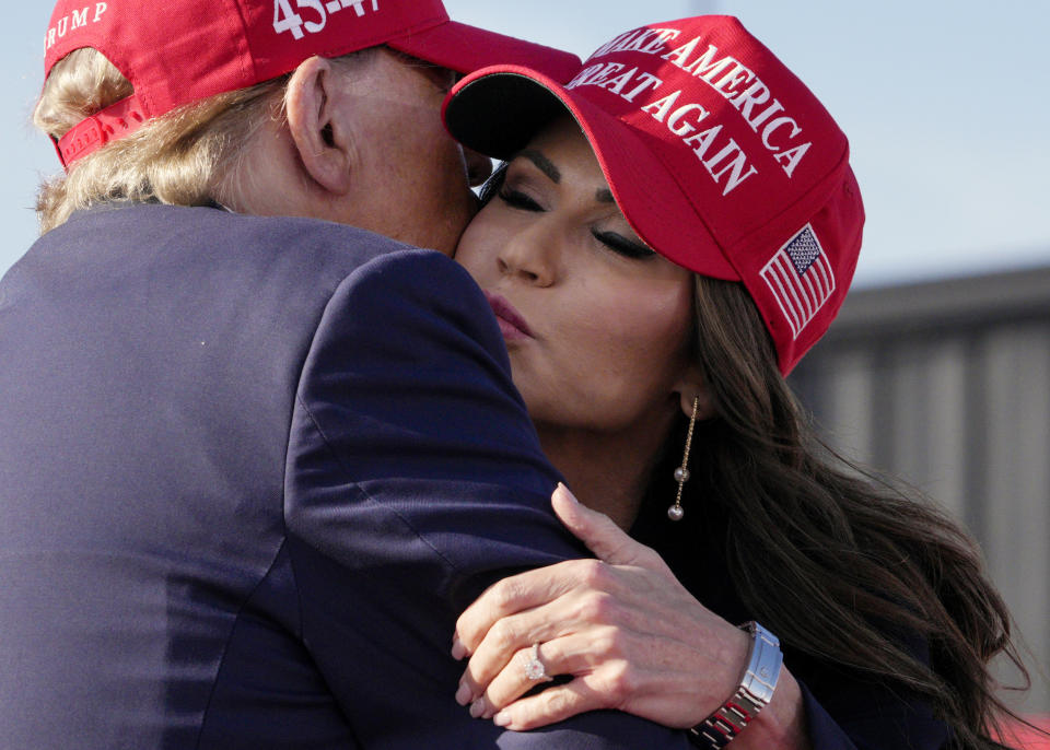 Republican presidential candidate and former President Donald Trump, left, embraces South Dakota Gov. Kristi Noem at a campaign rally, Saturday, March 16, 2024, in Vandalia, Ohio. (AP Photo/Jeff Dean)