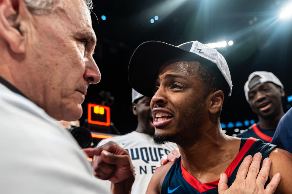 Duquesne 's Kareem Rozier, front right, congratulates head coach Keith Dambrot, left, after an NCAA college basketball game against Virginia Commonwealth in the championship of the Atlantic 10 Conference tournament Sunday, March 17, 2024, in New York. (AP Photo/Peter K. Afriyie)