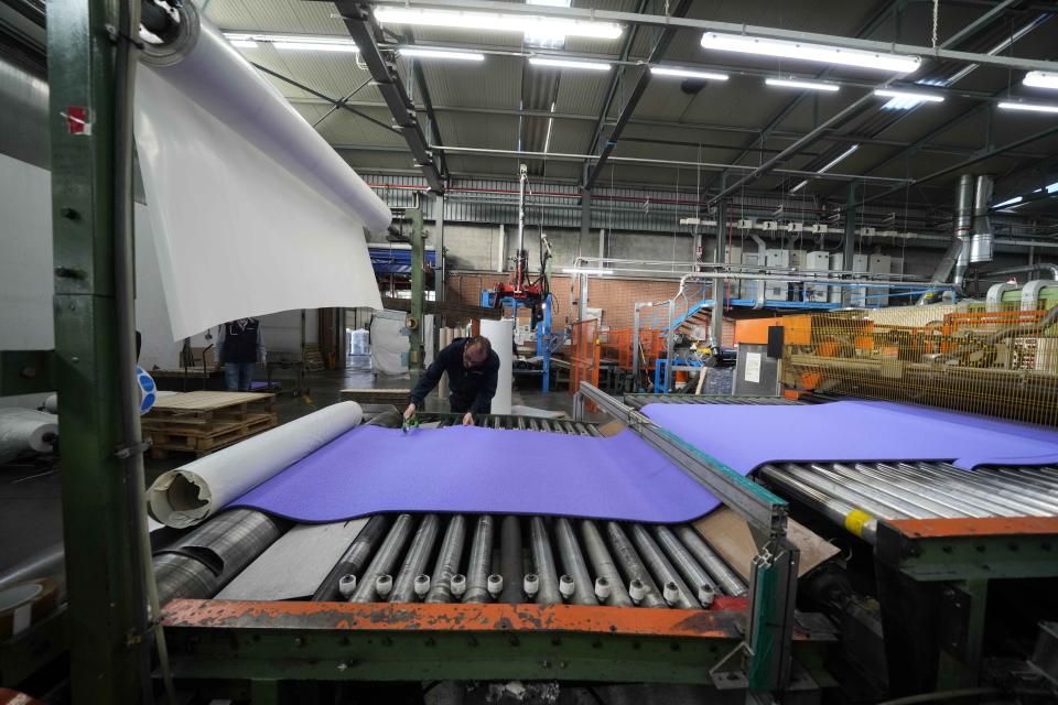 A worker checks the final surface of an athletics track, at the Mondo factory, in Alba, northern Italy, Wednesday, March 13, 2024. The athletics track for the upcoming Paris Olympics is being produced by the Mondo company at its factory in northern Italy. The track is made in portions, rolled up and then will be transported to the Stade de France, where it will be installed over the next month. (AP Photo/Luca Bruno)