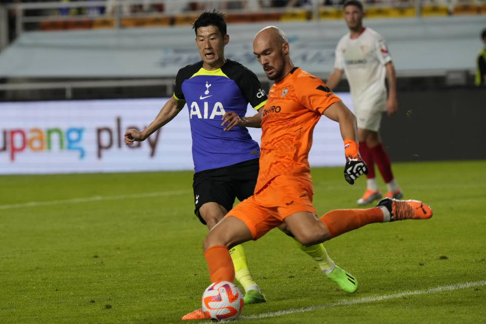 Tottenham Hotspur's Son Heung-min, left, fights for the ball with Sevilla FC goalkeeper Marko Dmitrovic during a preseason match at Suwon World Cup Stadium in Suwon, South Korea, Saturday, July 16, 2022.(AP Photo/Ahn Young-joon)