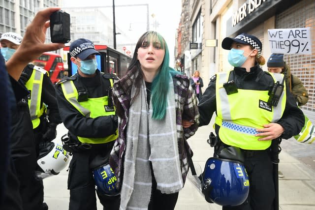 Police detain a woman during an anti-lockdown protest at Oxford Circus  