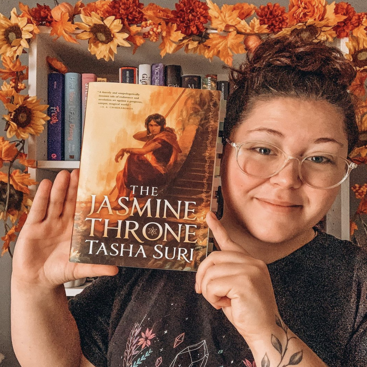 About me: Hi, I'm Jess, and I'm a 27-year-old book lover sharing my thoughts about the books I read like the true Virgo rising that I am. When I'm not reading or working (#RTstrong), I'm drinking coffee and playing the Nintendo Switch. I'm an enthusiast for all things warm, cozy, and fall-themed.What followers can expect: I talk a lot about queer books. You can expect a collection of reviews, open questions, and personal thought purges about my book journey. I love sapphic romance and fantasy books the most, but I try out books from other genres to make sure I don’t miss any amazing queer stories. I aim for my page to feel like a relaxing step away, if only for a second.A recent book I enjoyed: It's not recent, but it's a book that I think about at LEAST three times a day: The Jasmine Throne by Tasha Suri. A million out of five stars! The Jasmine Throne is an adult high fantasy book with two sapphic main characters that I will NEVER stop recommending. It’s my favorite book and reminded me of why I love reading in the first place.