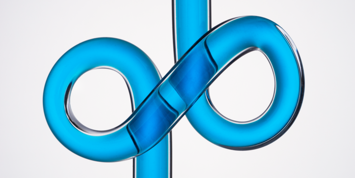 infinity symbol shaped glass tube with blue liquid on white background