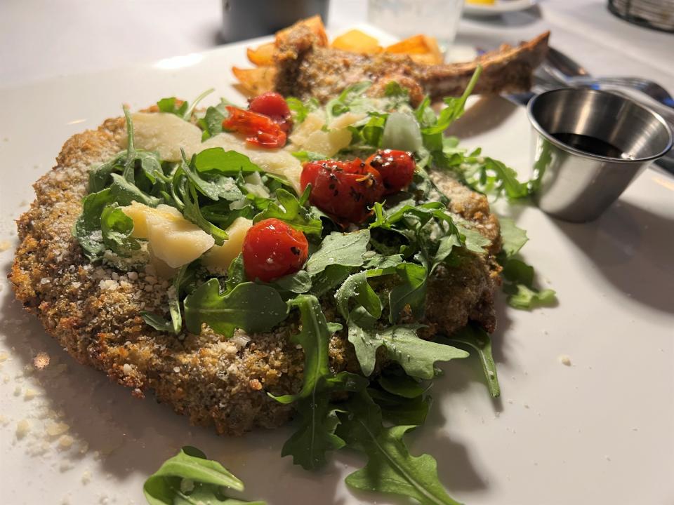 At Ristorante Corleone in Port St. Lucie, the veal Milanese is a large bone-in veal chop pounded thin, breaded, sauteed and garnished with a pile of fresh peppery arugula, chopped tomatoes, shaved Parmigiano Reggiano and balsamic glaze.