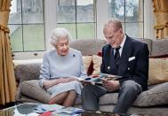 <p>The royal couple smiles at a card made by the Cambridge children in a portrait taken for their 73rd wedding anniversary. </p>