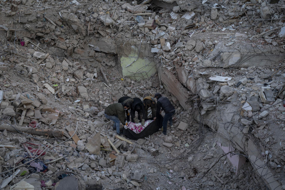 The body of a woman who died during the earthquake is placed inside a plastic bag after being pulled from the rubble of a destroyed building in Antakya, southeastern Turkey, Wednesday, Feb. 15, 2023. The earthquakes that killed more than 39,000 people in southern Turkey and northern Syria is producing more grieving and suffering along with extraordinary rescues and appeals for aid. (AP Photo/Bernat Armangue)