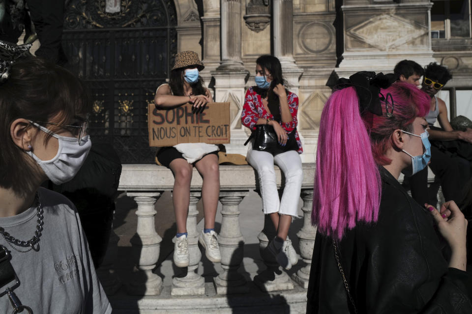 Women's rights activists protest against French President Emmanuel Macron's appointment of an interior minister who has been accused of rape and a justice minister who has criticized the #MeToo movement, in front of Paris city hall, in Paris, France, Friday, July 10, 2020. The French government said it remains committed to gender equality and defended the new ministers, stressing the presumption of innocence. Gerald Darmanin, Interior Minister, firmly denies the rape accusation, and an investigation is underway. New Justice Minister Eric Dupond-Moretti is a lawyer who has defended a government member accused of rape and sexual assault, and has ridiculed women speaking out thanks to the #MeToo movement. (AP Photo/Francois Mori)