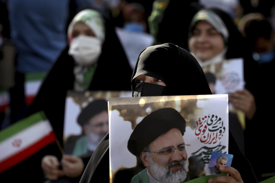 A supporter of presidential candidate Ebrahim Raisi holds a sign during a rally in Tehran, Iran, Wednesday, June 16, 2021. Iran's clerical vetting committee has allowed just seven candidates for the Friday, June 18, ballot, nixing prominent reformists and key allies of President Hassan Rouhani. The presumed front-runner has become Ebrahim Raisi, the country's hard-line judiciary chief who is closely aligned with Supreme Leader Ayatollah Ali Khamenei. (AP Photo/Ebrahim Noroozi)