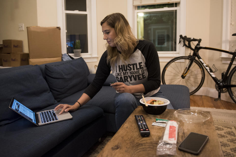 BOSTON, MA - AUGUST 29: Regan Cleminson eats her takeout while multitasking behind her phone, computer and TV in her apartment in South Boston on Aug. 29, 2017. Cleminson is part of a booming growth in food delivery, driven by millennials such as herself through services like Grubhub and Foodler. (Nicholas Pfosi for The Boston Globe via Getty Images)