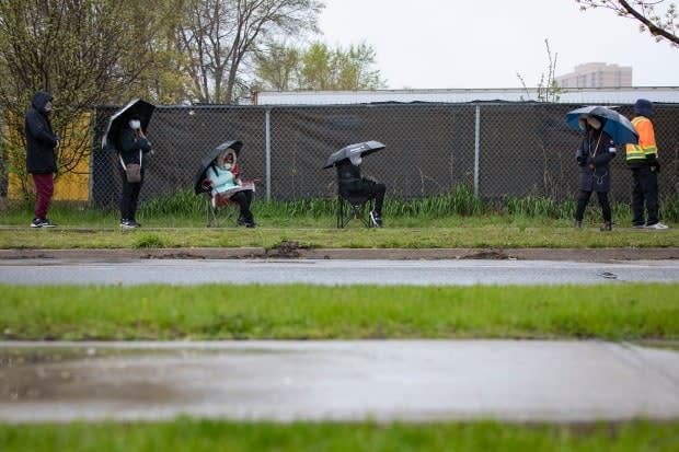 People line up outside Downsview Arena in northwest Toronto to get a COVID-19 vaccine on April 29. The province says all Ontarians over the age of 18 are expected to be eligible for a COVID-19 vaccine within one month. 