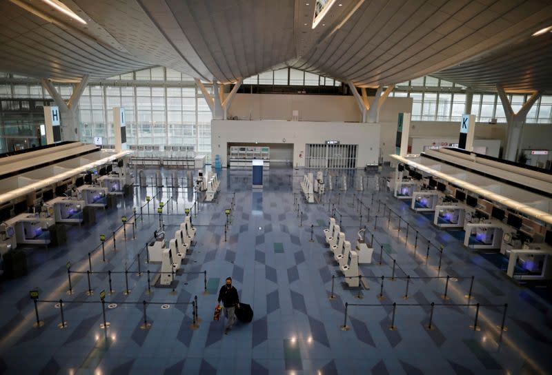 A passenger is seen at the check-in area of the international flight terminal at Haneda airport in Tokyo