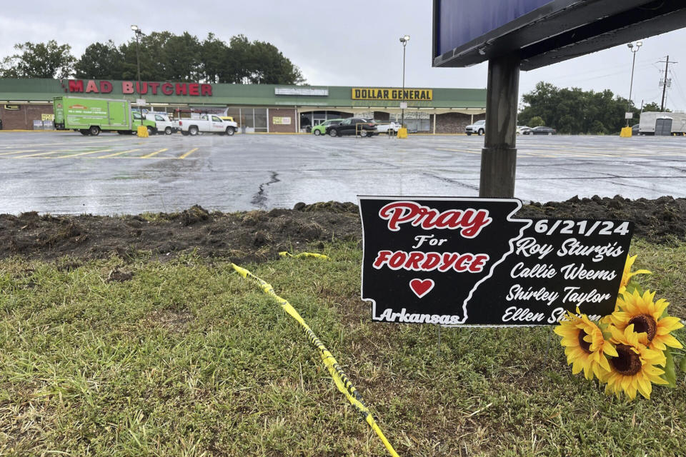 A sign in memory of the four victims killed in a mass shooting at the Mad Butcher grocery store sits near the store's parking lot in Fordyce, Ark., on Wednesday, June 26, 2024. (AP Photo/Andrew DeMillo)