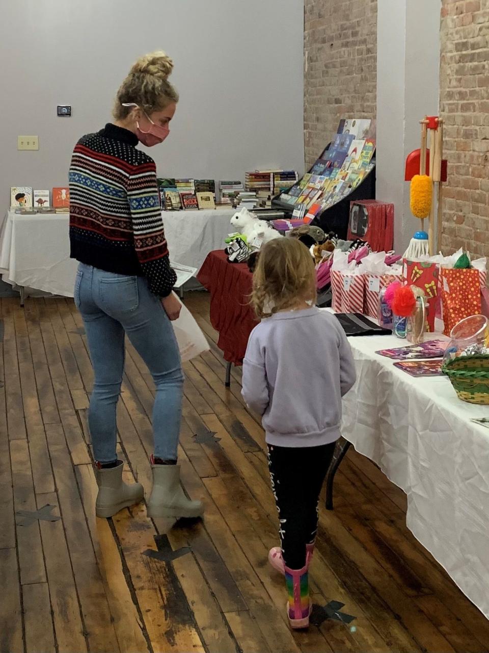 A volunteer helps a youngster pick out gifts during last year's Tiny Tim Christmas Shoppe.