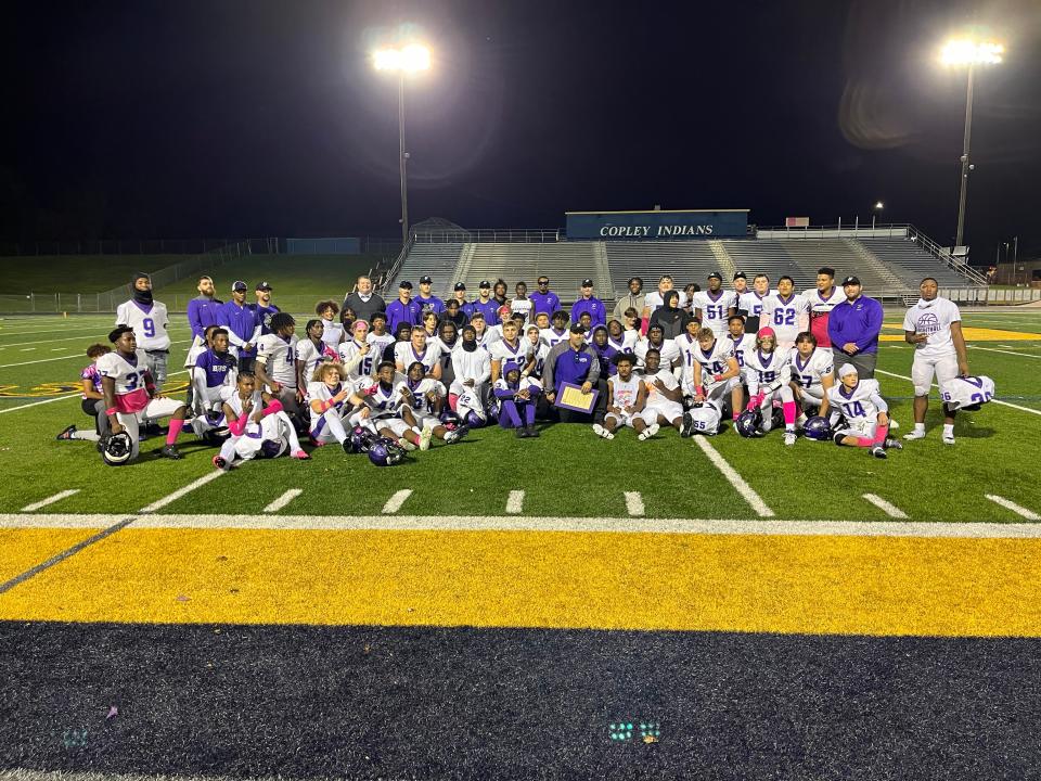 Barberton football coaches and players surround head coach Tony Gotto, middle with a proclamation in his hands, after a win over Copley on Oct. 6, 2023. The victory gave Gotto the most wins by a head coach in Barberton football history.