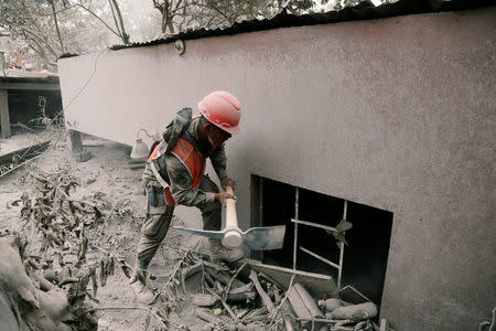 A soldier uses a pick at an area affected by the eruption of the Fuego volcano in the community of San Miguel Los Lotes in Escuintla, Guatemala June 5, 2018. REUTERS/Luis Echeverria