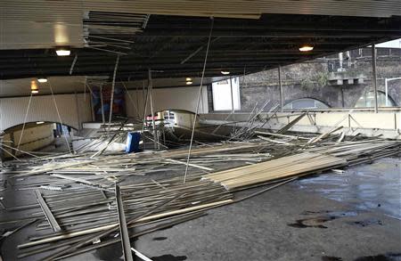 The roof of a pedestrian bridge which collapsed during strong winds is seen outside London Bridge Station in London October 28, 2013. REUTERS/Dylan Martinez