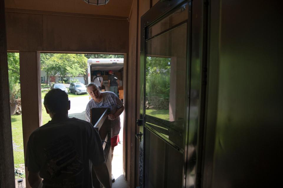 Craig Coburn-McDonald and Melissa McDonald load part of her bed frame into his house on July 31, 2023.